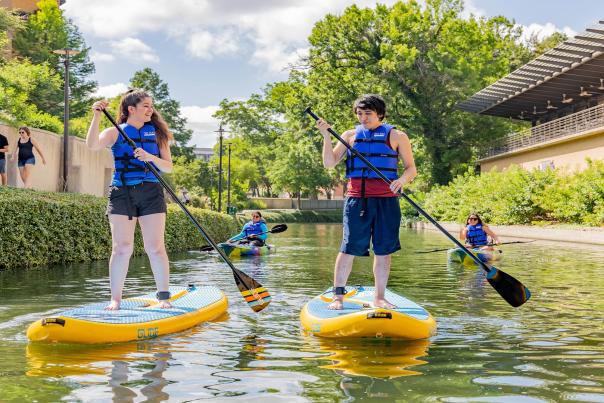 People paddle boarding on San Antonio River Walk