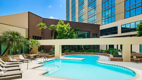 Hotel pool with lounge seating around it.