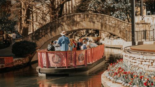 Barge carrying people floating down River Walk