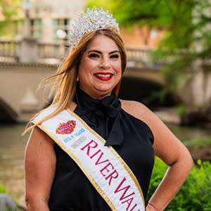 woman wearing dress on river walk with royalty sash