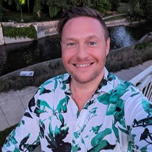 man posing taking photo by river walk