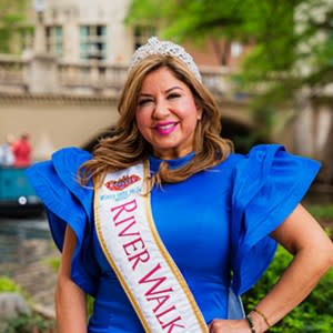 woman posing in blue dress with royalty Queen sash