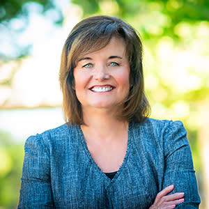 Professional headshot of woman with arms crossed