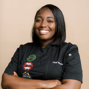 Woman in chef jacket with arms crossed