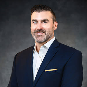Professional headshot of man with beard smiling
