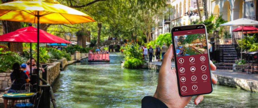 Hand holding a phone with the Visit San Antonio App