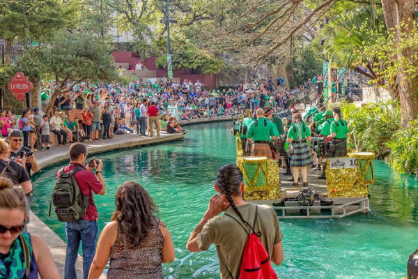 Spectators gathering around river dyed green and river barge Bud Light St. Patricks River Parade