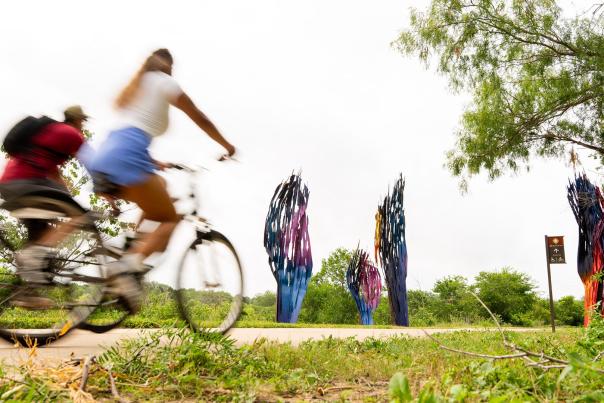 biking on path next to public art