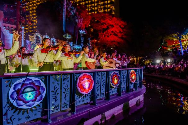 Mariachi band members on a river barge drifting in the Day of the Dead River Parade.