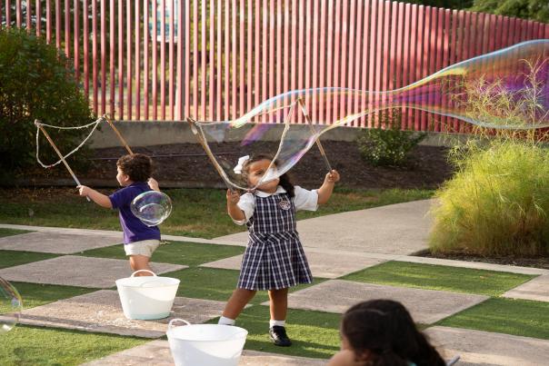 kids blowing bubbles outside