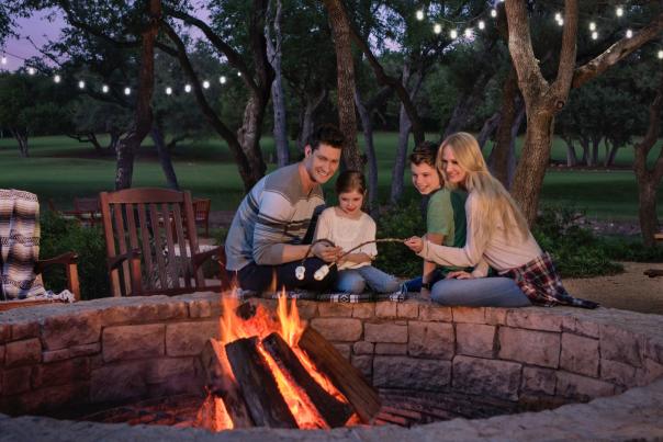 Family sitting be campfire outside