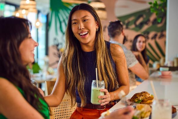 Two girls laughing over lunch
