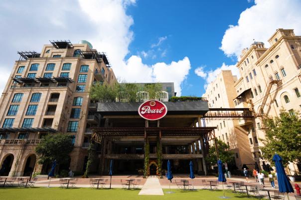 Green courtyard in front of tall Pearl building