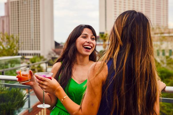 Two girls holding drinks and laughing