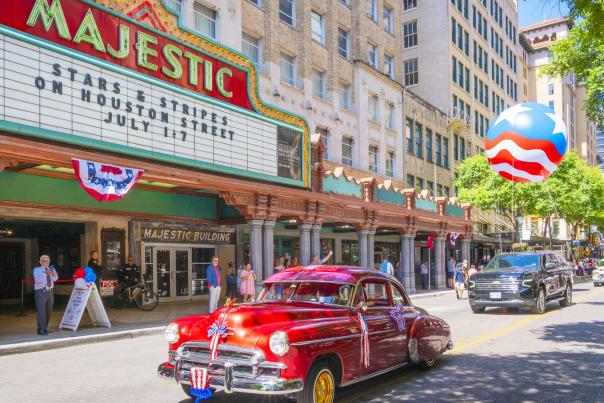 Classic red car driving in front of Majestic Theatre