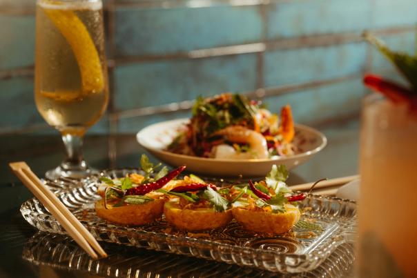 Tokyo Cowboy dinner spread with tall beverage glass.