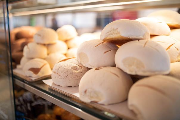 Conchas stacked on top of each other in display case at La Panaderia.