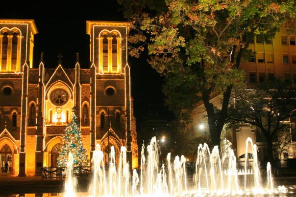 Water fountain in front of lit church at night