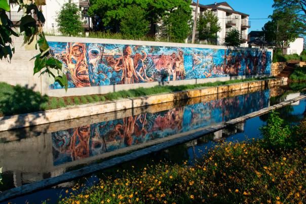 Public art along wall in front of creek