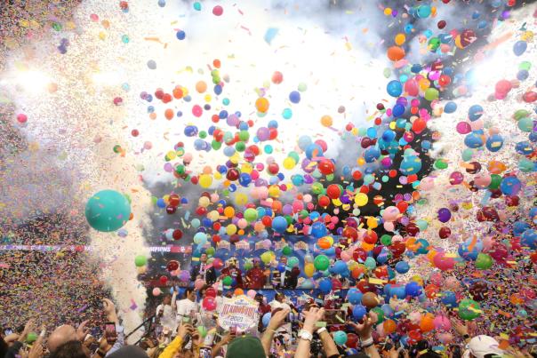 Balloons and smoke falling over football field in celebration.