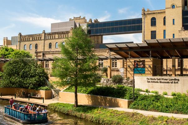 River barge passing by exterior of San Antonio Museum of Art.