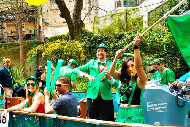 River barge filled with people dressed in green celebrating St. Patrick's Day.