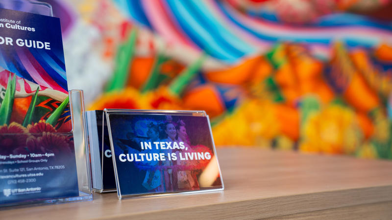Framed graphic with mural in background at Institute of Texas Cultures in San Antonio.