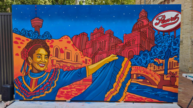 Mural of woman in Foloriko dress smiling front of Pearl.