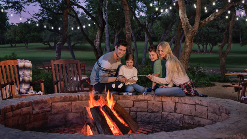 Family sitting be campfire outside