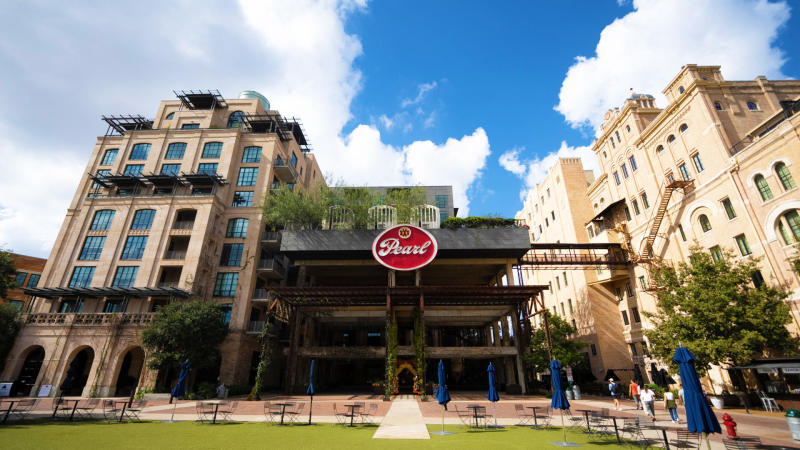 Green courtyard in front of tall Pearl building