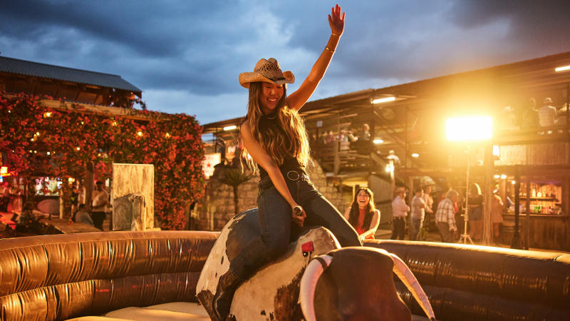 Girl on mechanical bull at Tejas Rodeo