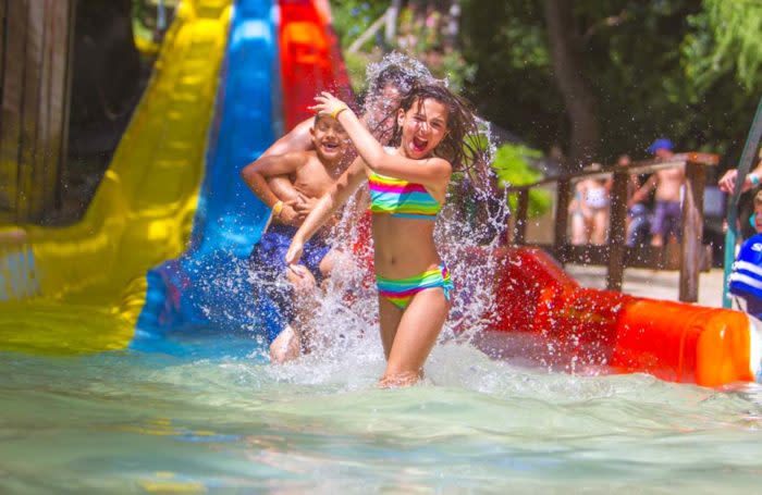Girl walking away from waterslide splashing water