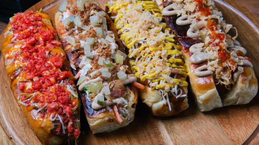 Gourmet hot dogs plated with toppings at Big Aztec Corner Bar in San Antonio