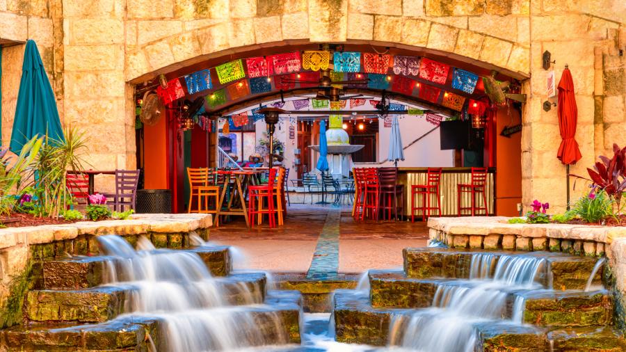 Arches and waterfall at Casa Rio with colorful papel picado in background.