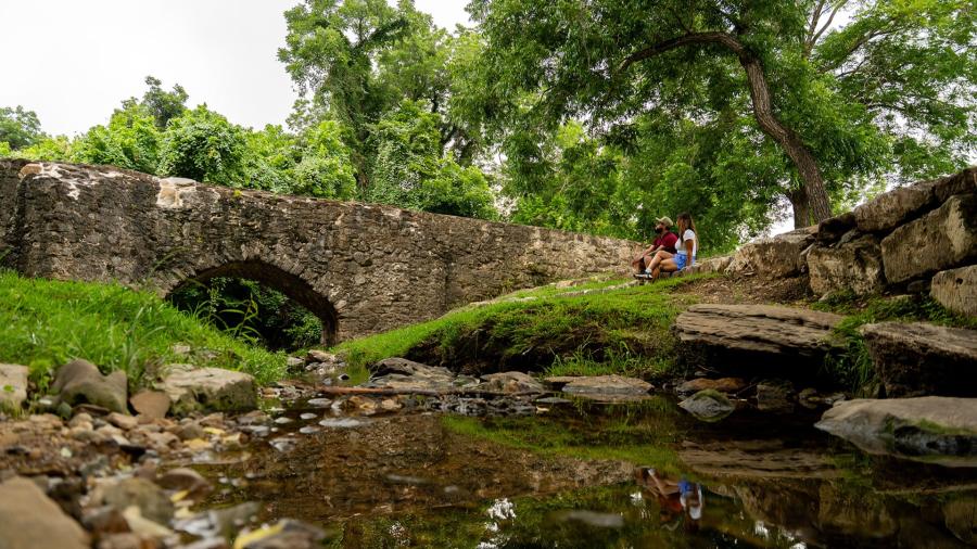 two people looking at mission espada aqueduct