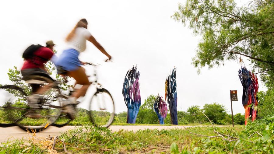 biking on path next to public art