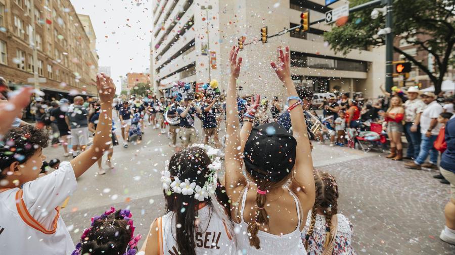 children cheering at street parade with confetti