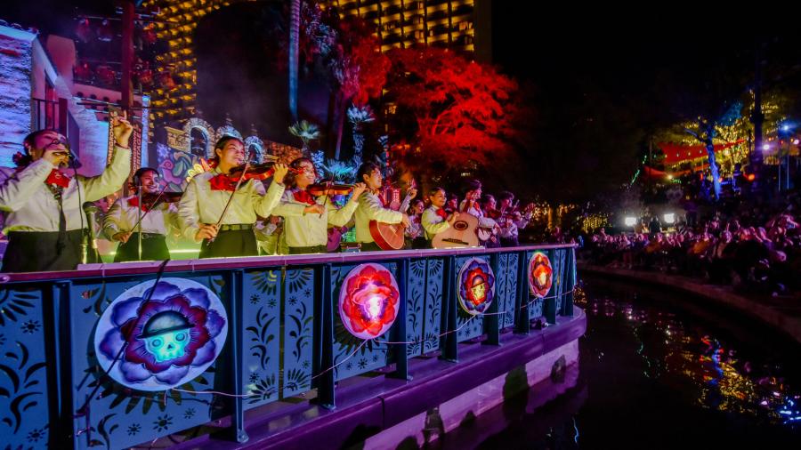 Mariachi band members on a river barge drifting in the Day of the Dead River Parade.
