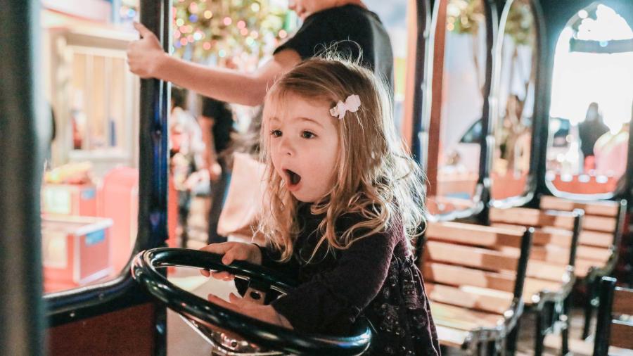 Little girl playing on trolley at The DoSeum.