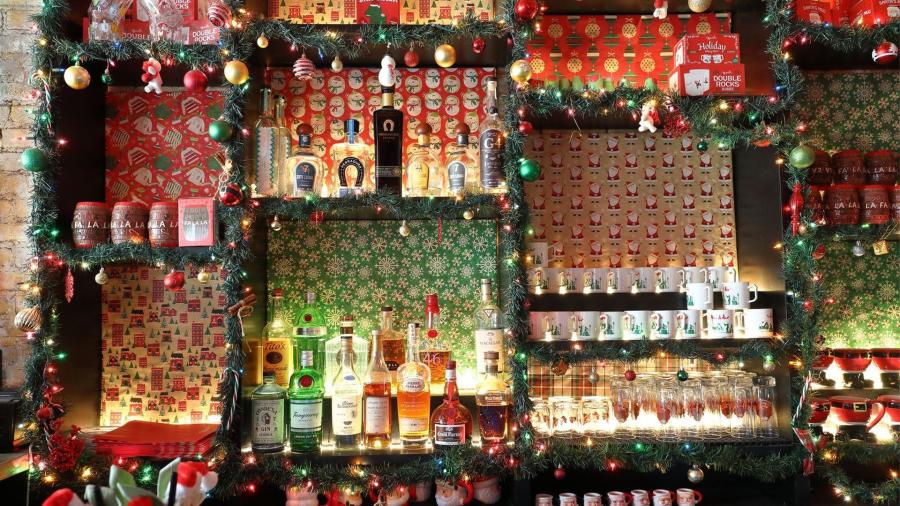 Bar decorated for the holidays with wrapping paper, ornaments, and holiday lights.