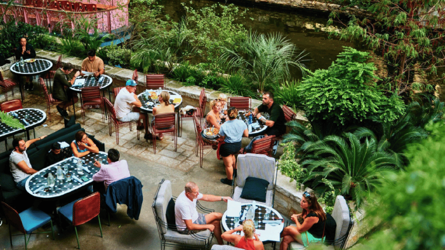 guests dining on a patio by the River Walk