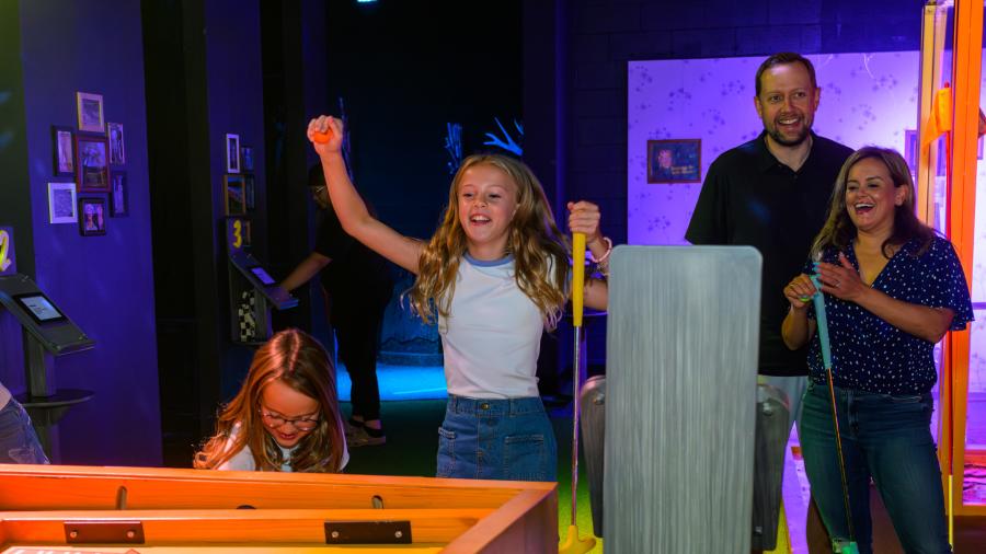 Family cheering on daughter/sister at Holey Moley mini golf in San Antonio.