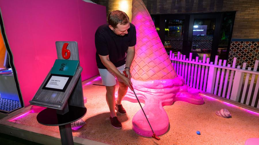 father playing mini golf at Holey Moley