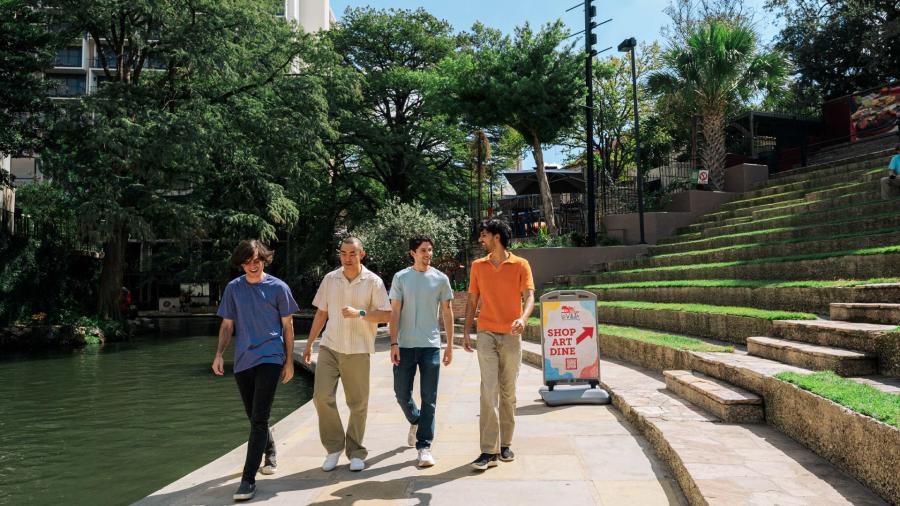 Group of men walking along River Walk in San Antonio.