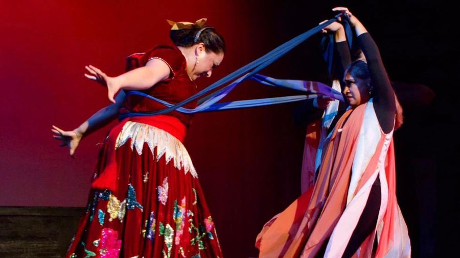 Two women in theatrical performances with cultural dresses and scarfs.