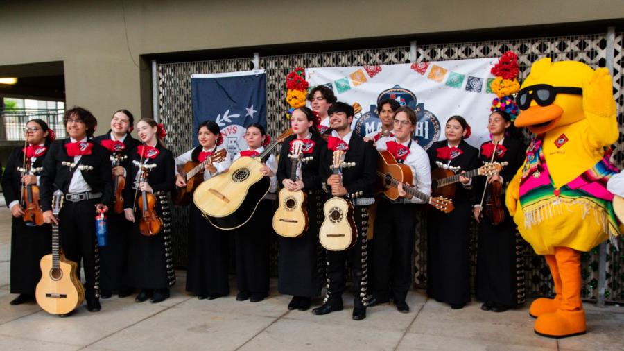 Timmy Duckin, River Walk duck mascot posing with group of mariachi band members.