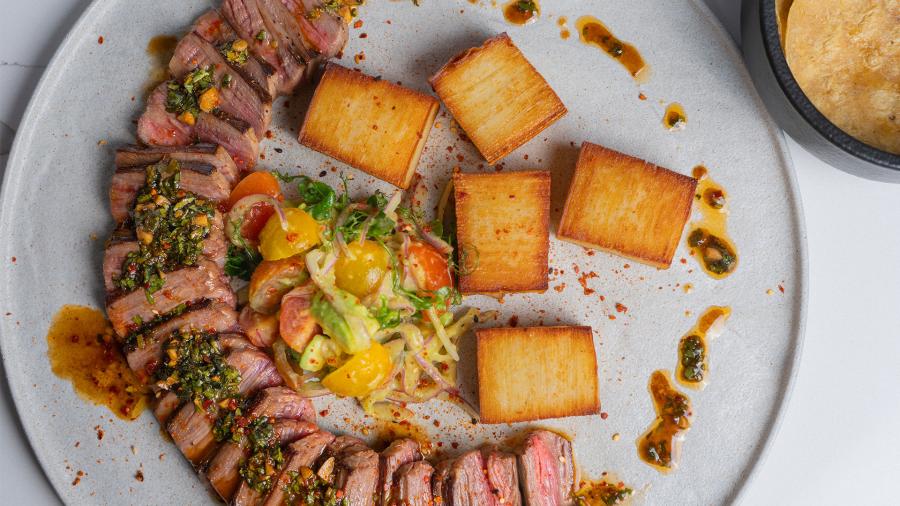 Overhead view of plated steak and frites at Esencia at St. Anthony hotel in San Antonio.