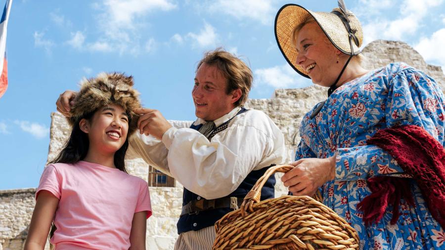Girl at the Alamo with character re-enactors.