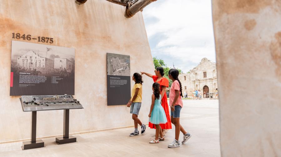 Family walking through exhibit outside of the Alamo in San Antonio, Texas.