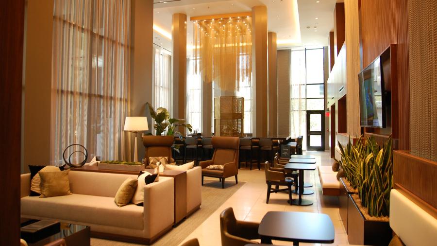 Hotel lobby with warm lighting and dangling chandeliers.